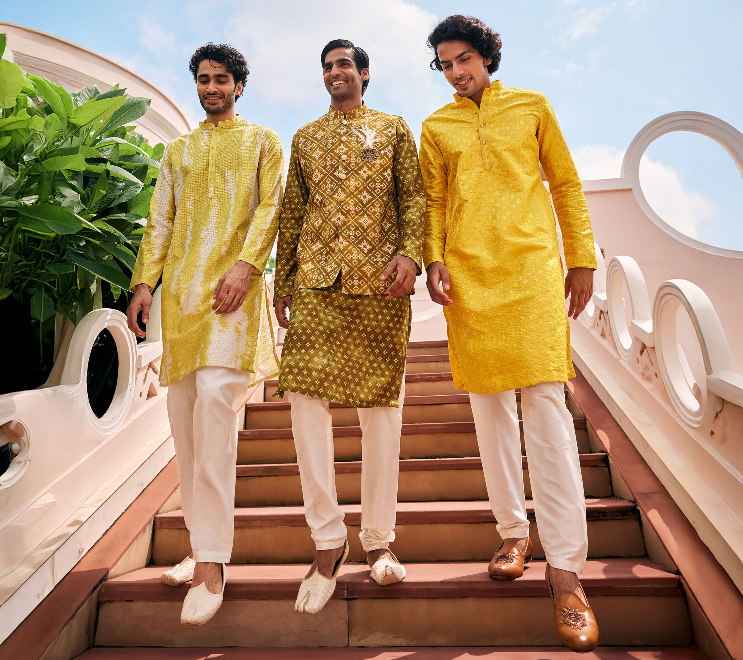 Three men in coordinated yellow and gold ethnic wear, styled for festive Ganesh Chaturthi celebrations